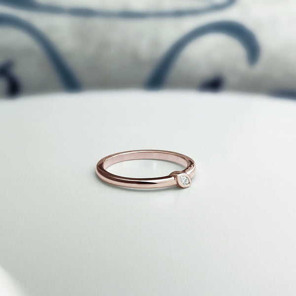 Solid rose gold stacking ring with natural marquise diamond in a bezel setting.
