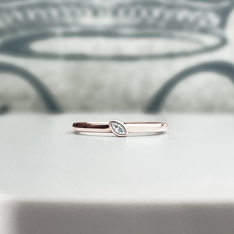 Solis rose gold stacking ring with a bezel set marquise diamond on placed at an angle. Customize this ring! Ask us how.