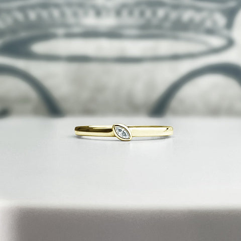 Solid yellow gold stacking ring with bezel set marquise diamond. Customize this ring!